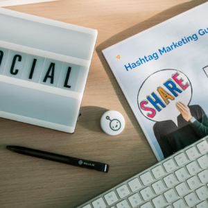 A desktop setup with social media marketing essentials including a keyboard, lightbox, and guide.