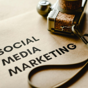 Close-up of a camera placed on brown paper with 'Social Media Marketing' text, emphasizing digital marketing themes.